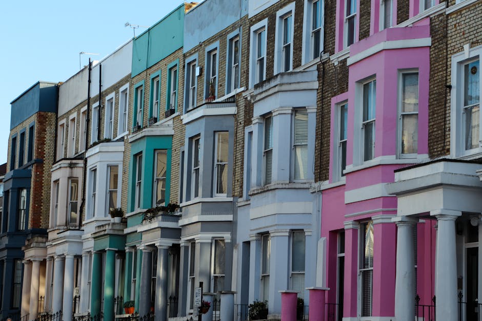 A row of Victorian-era terraced houses on Upper Street featuring red brick facades accented with white decorative architectural details, including ornate cornices, window surrounds, and columned doorw